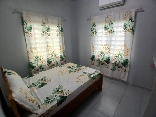 a small bed in a room with curtains and a bed sidx sidx sidx at Maitidi Place in Paramaribo