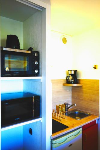 a kitchen with a microwave and a sink at Stosy Gare in Caen