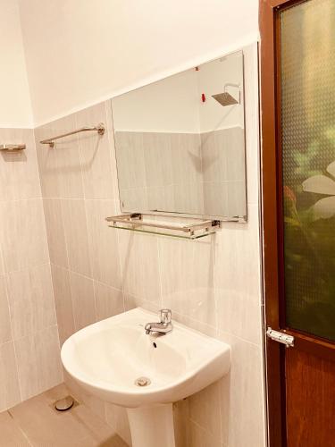 a bathroom with a sink and a mirror at Hotel Nimthera in Kuruwita