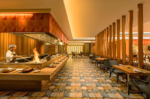 a restaurant with a chef preparing food in a kitchen at Hyatt Pune in Pune