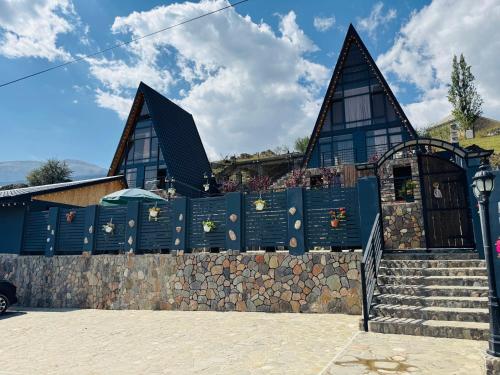 a blue building with a stone wall and stairs at Haven A frame Shahdag in Qusar