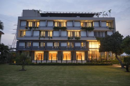 a large white building with a lawn in front of it at Moolchand Resort in Muzaffarnagar