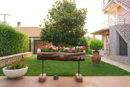 a wooden planter with flowers in a yard at Cozy flats in an olive grove by the sandy beach in Kánalos