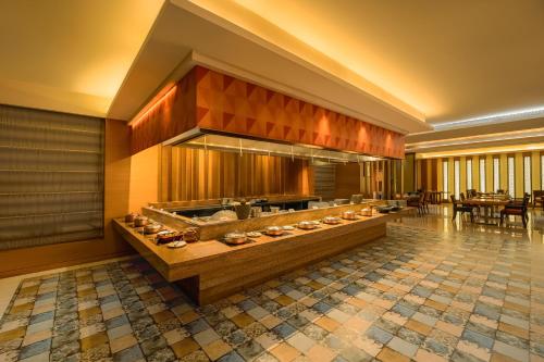 a lobby of a hotel with a restaurant with tables at Hyatt Pune in Pune
