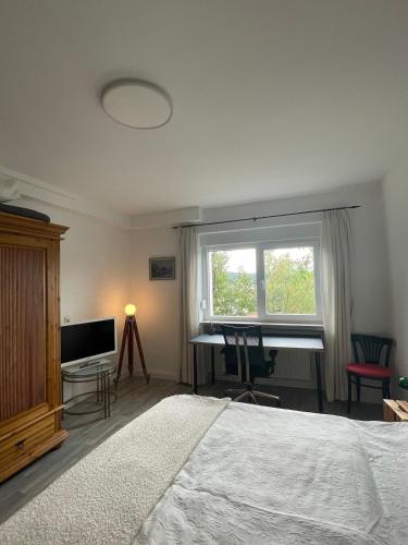 a bedroom with a bed and a piano and a television at Sehr schöne neu renovierte Ferienwohnung Spechthöhle in Wehrheim