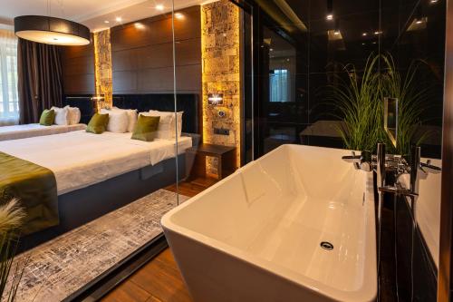 a bathroom with a bath tub and a bed at Family Hotel Strannopriemnitza in Oreshak