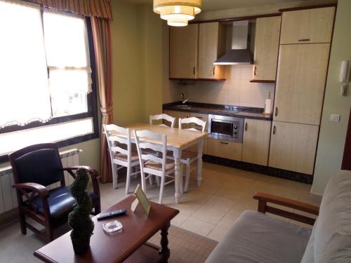 a kitchen and dining room with a table and chairs at Apartamentos la Marina in Ribadesella