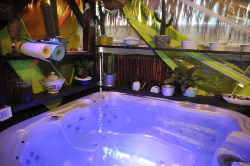 a bathroom with a large tub with potted plants at Ahuzat Shaul Seaside in H̱adera