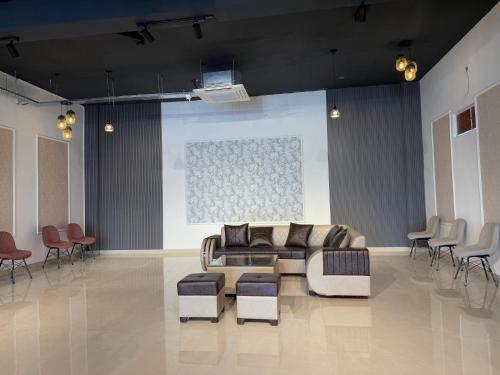 a living room with a couch and tables and chairs at Hotel Sky Suites in Gurgaon