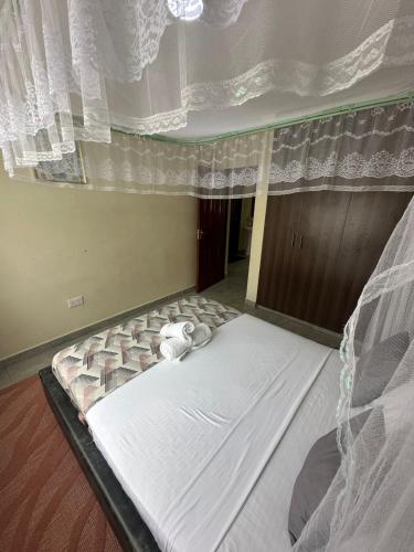 a large bed in a room with a window at Ecostay 3bedroom ground floor in Kisumu
