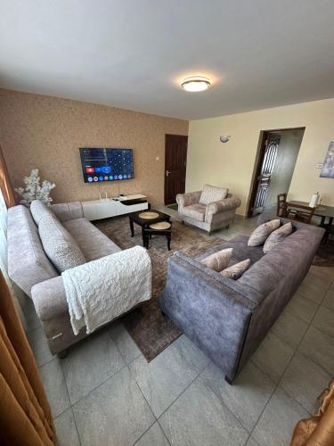 a living room with two couches and a tv at Ecostay 3bedroom ground floor in Kisumu