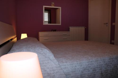 a bedroom with a bed and a dresser and a mirror at Villetta Airone in Birgi Vecchi