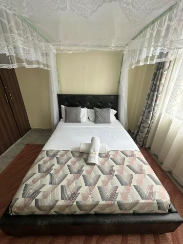 a bedroom with a large bed with two towels on it at Ecostay 3bedroom ground floor in Kisumu