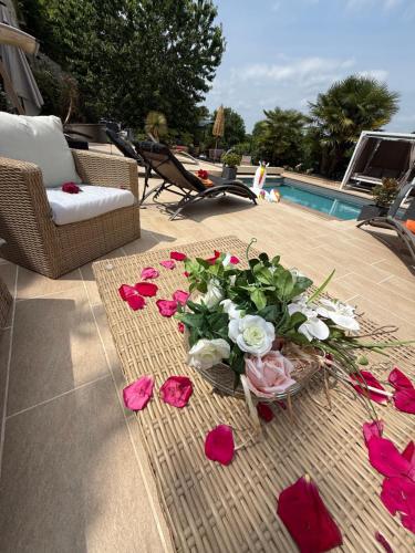a bouquet of flowers on a table next to a pool at Sddeco in Nerville-la-Forêt