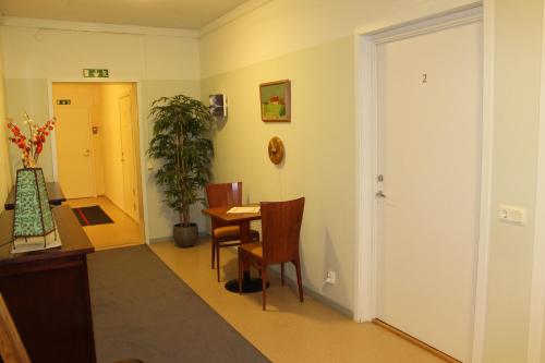 a hallway with a table and chairs in a room at Stationshusets Hotell och Café in Köping