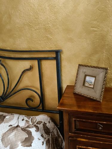 a bedroom with a bed and a table with a picture on it at Alla Meria in Castiglione della Pescaia