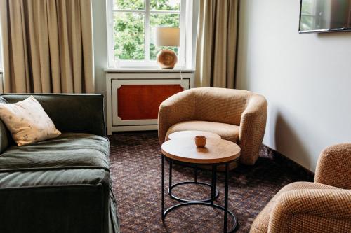a living room with two chairs and a table at Landhotel Kauzenberg in Bad Kreuznach