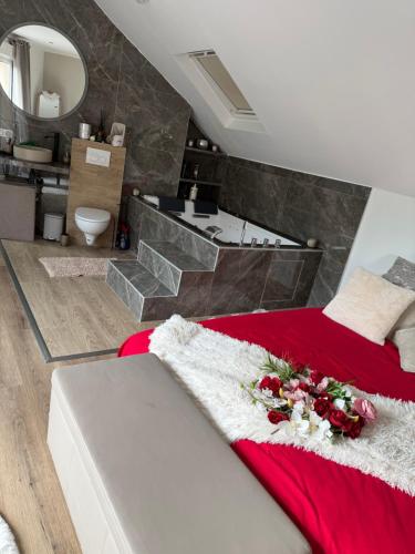 a bedroom with a red bed and a bathroom at Sddeco in Nerville-la-Forêt