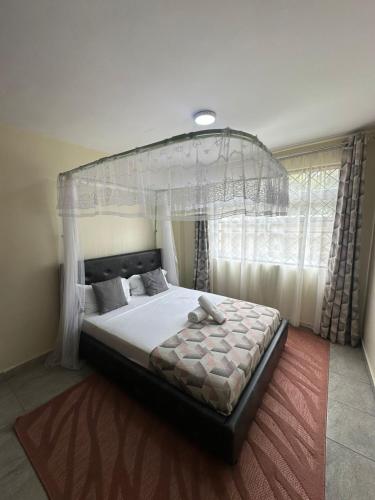 a bedroom with a bed with a canopy at Ecostay 3bedroom ground floor in Kisumu