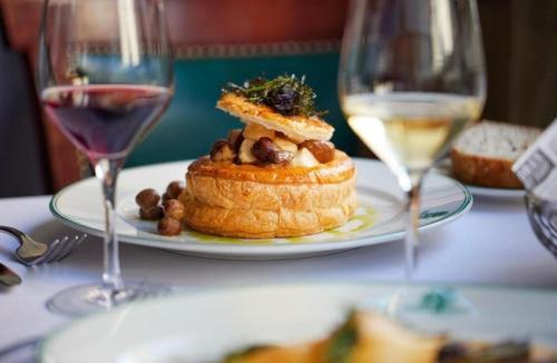 a plate of food on a table with two wine glasses at Hanza Tower 22 WHITE Jacussi & Sauna & Pool & SPA in Szczecin