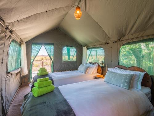 a bedroom with two beds in a tent at Camp Doros in Twyfelfontein