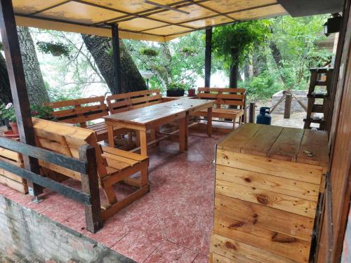 a patio with wooden benches and a table and chairs at Vikendica na Tisi in Ada