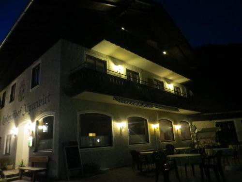 a building with a balcony at night with lights at Garni Haus Jagerwirt in Fuschl am See