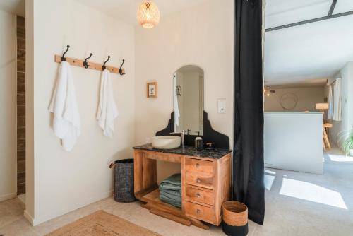 une salle de bain avec un lavabo et un miroir dans l'établissement La Grangerie, à Moulézan