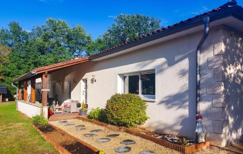 a white house with a window and a yard at Cozy Home In Sarliac With Wifi in Bujadelle