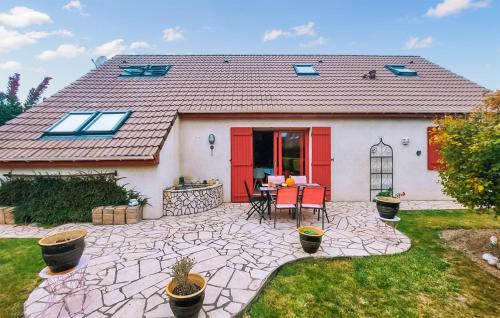 TéteghemにあるStunning Home In Teteghem With Wifiのテーブルと椅子のあるパティオのある家