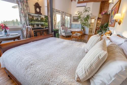 a bedroom with a large bed and a living room at Ha'Seuda Ha'Achrona Suites in Amirim
