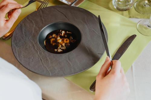 a person holding a knife and a bowl of food at Hotel De Zevensprong in Binneheide