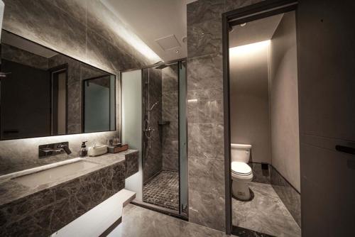 a bathroom with a shower and a toilet and a sink at Pilot Hotel in Chongqing