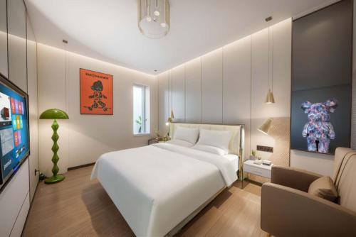 a bedroom with a large white bed and a tv at Pilot Hotel in Chongqing