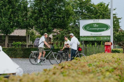 a group of three people on bikes near a sign at Hotel De Zevensprong in Binneheide