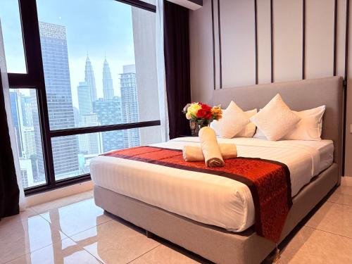 a bedroom with a bed with a vase of flowers on it at Luxury Axon Residence Bukit Bintang KLCC 2 Minutes Walking PAVILION in Kuala Lumpur