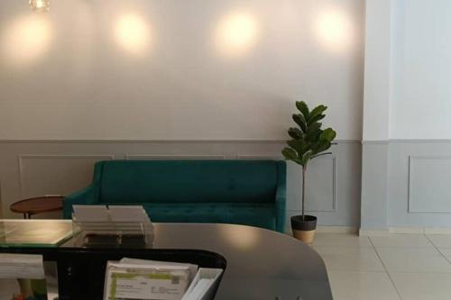 a living room with a green couch and a table at Mars Hotel in Kuala Lumpur