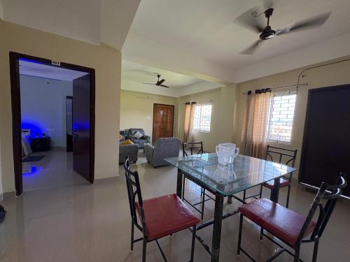 a dining room and living room with a table and chairs at DXK Villa Homestay in Guwahati