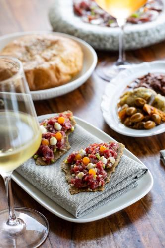 a table with plates of food and glasses of wine at Carlton Tel Aviv Hotel – Luxury on the Beach in Tel Aviv
