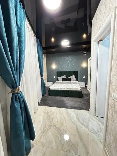a bedroom with a bed with blue curtains in it at PENSIUNEA Ana in Buftea