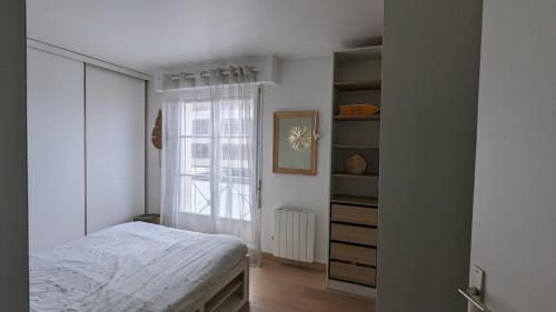 ポワシーにあるBel appartement, proche gare, Poissy- Ouest Parisのベッドと窓のある白い寝室