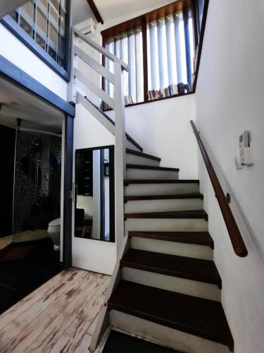 a staircase in a house with white walls and wooden floors at Glamping Merida Vendégház in Orfalu