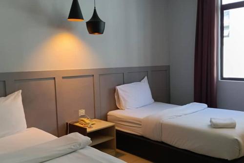 a hotel room with two beds and a window at Mars Hotel in Kuala Lumpur