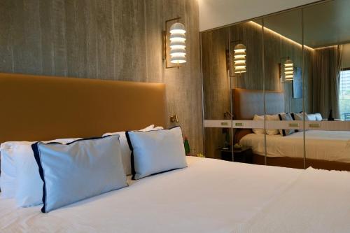 a bedroom with a large bed with blue pillows at Carlton Tel Aviv Hotel – Luxury on the Beach in Tel Aviv