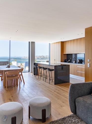 an open kitchen and living room with a table and chairs at Bellevue | Sea & River View | Garage in Canidelo