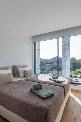a bedroom with a large bed with a large window at Bellevue | Sea & River View | Garage in Canidelo