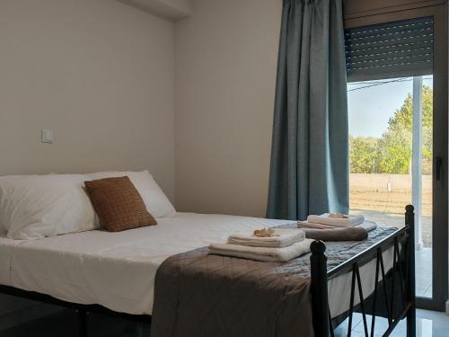 a bedroom with a bed with towels on it at Olympic Flame Suites in Pýrgos