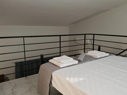 a bed with white sheets and towels on it at Olympic Flame Suites in Pýrgos