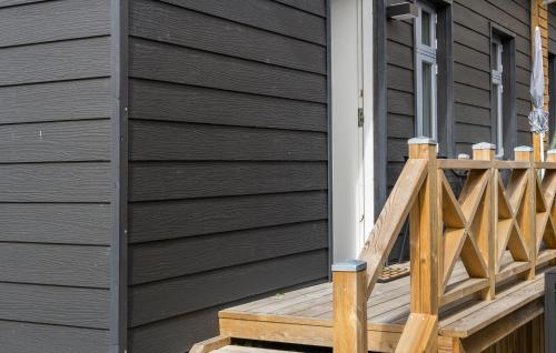 a house with a wooden deck next to a house at Stunning Apartment In Bogense With Wifi in Bogense