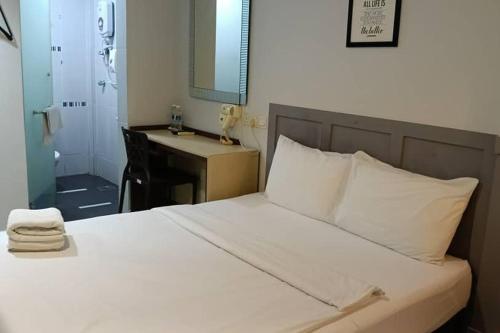 a bedroom with a bed with a sink and a mirror at Mars Hotel in Kuala Lumpur